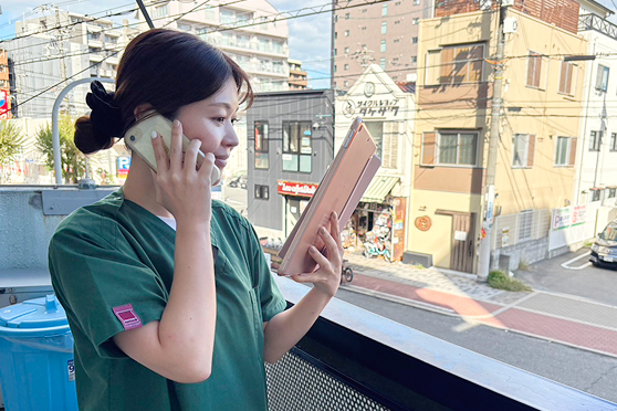 電話で情報共有を行うスタッフ